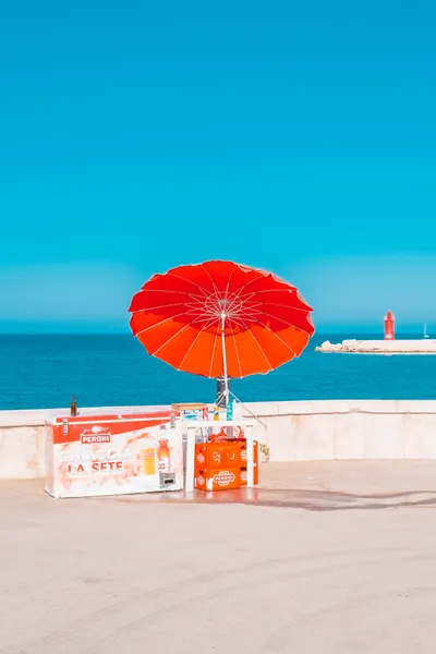 Red Umbrella Ocean View by Roberto Ruoli