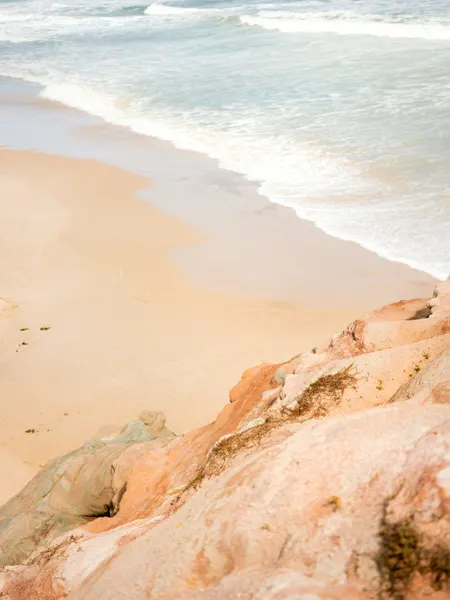 Sandy Beach Meeting Rocky Cliffs by Raisa Zwart