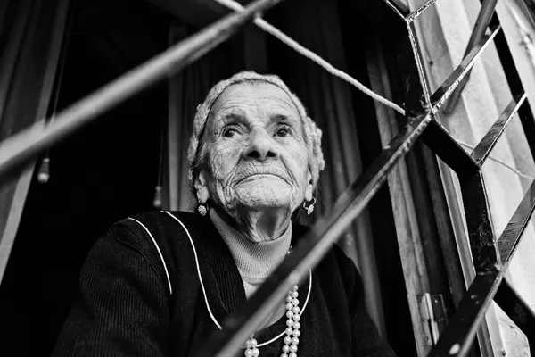 Elderly Woman Behind Bars by Josefina Melo